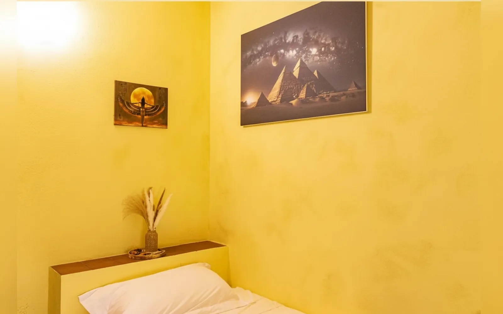Il letto della camera Iside e i quadri a tema egizio alle pareti